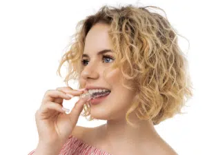 Patient holding clear aligner model while learning about starting orthodontic treatment