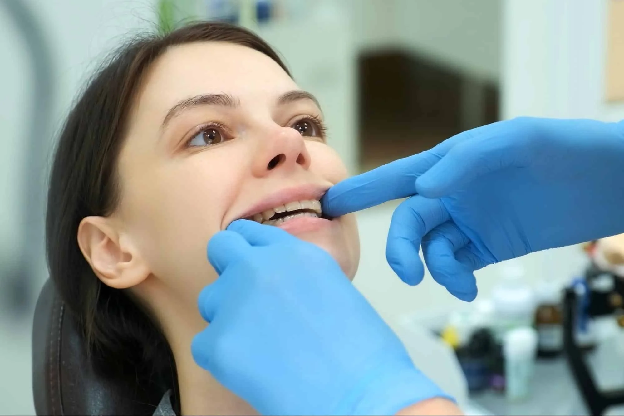 Orthodontist checking a patient's teeth and braces.